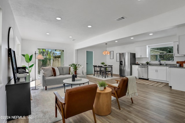 living room with light wood-type flooring and sink