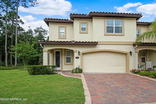 mediterranean / spanish-style home featuring a front yard and a garage