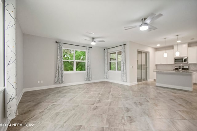 unfurnished living room with ceiling fan