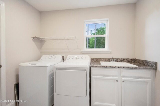 washroom featuring separate washer and dryer, sink, and cabinets