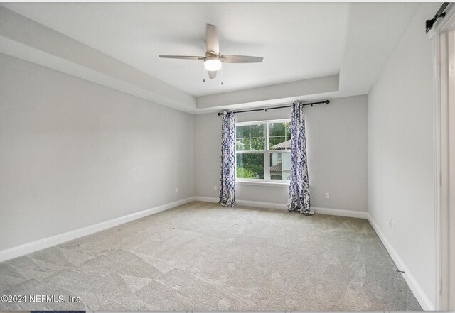 empty room featuring ceiling fan and light colored carpet