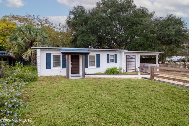 view of front of property featuring a front yard and a carport