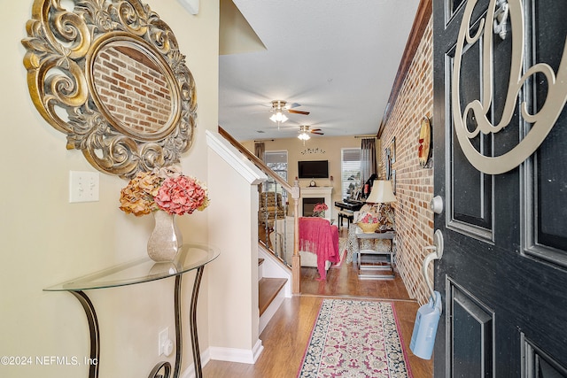 entrance foyer featuring brick wall, dark hardwood / wood-style flooring, and ceiling fan