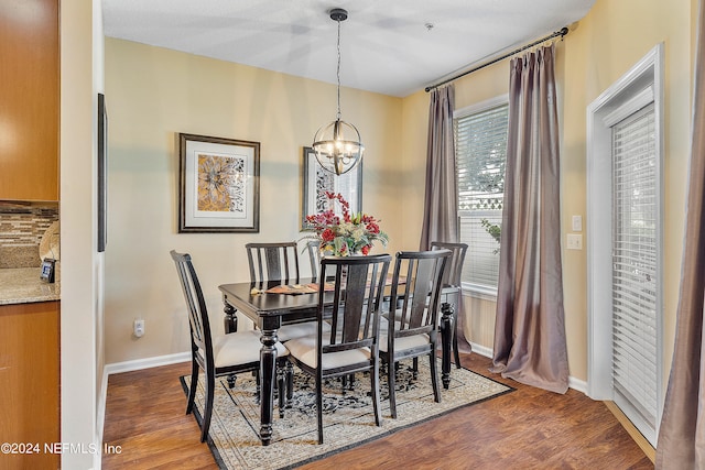 dining room with hardwood / wood-style floors and a notable chandelier