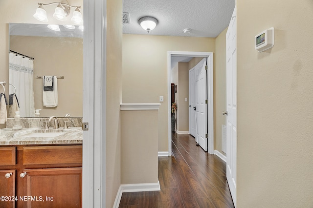 hall with a textured ceiling, sink, and dark hardwood / wood-style flooring