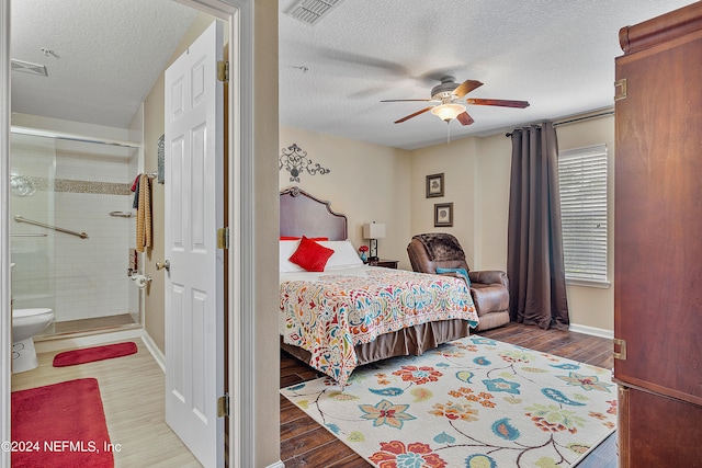 bedroom featuring ensuite bath, ceiling fan, hardwood / wood-style floors, and a textured ceiling