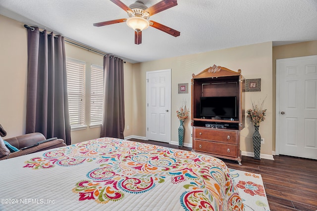 bedroom with ceiling fan, dark hardwood / wood-style floors, and a textured ceiling