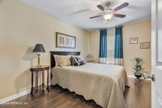 bedroom featuring ceiling fan, dark wood-type flooring, and a textured ceiling