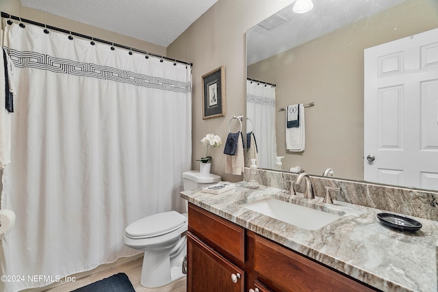 bathroom featuring a textured ceiling, wood-type flooring, vanity, and toilet