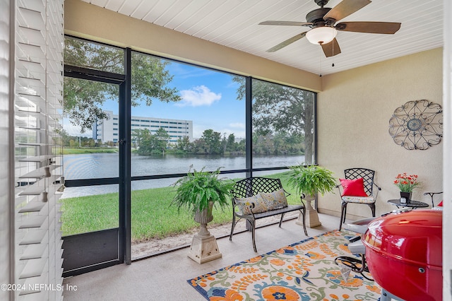 sunroom / solarium featuring wood ceiling, a water view, and ceiling fan