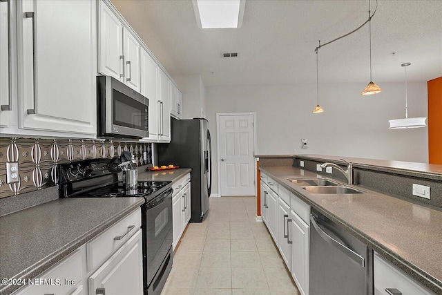 kitchen with pendant lighting, white cabinets, sink, tasteful backsplash, and stainless steel appliances