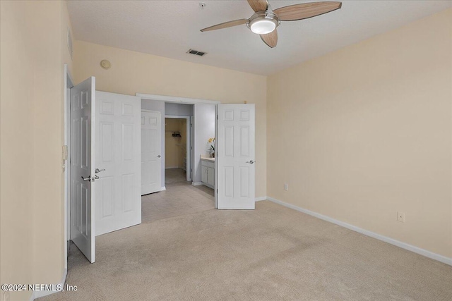 unfurnished bedroom with ceiling fan and light colored carpet