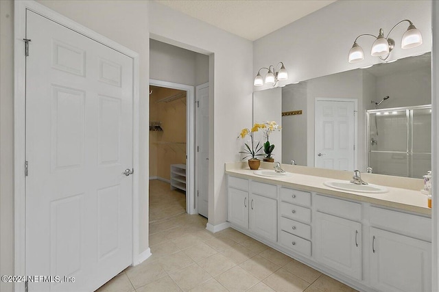 bathroom featuring tile patterned flooring, vanity, and walk in shower