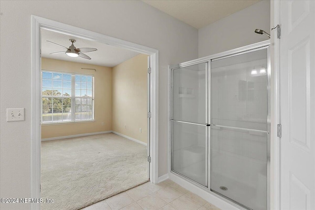 bathroom featuring a shower with door, tile patterned floors, and ceiling fan