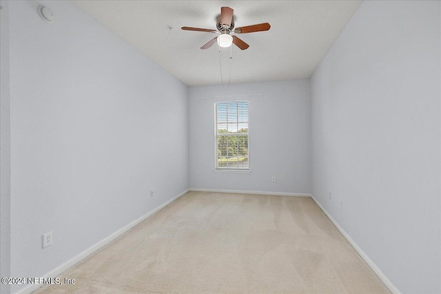 spare room with light carpet and ceiling fan