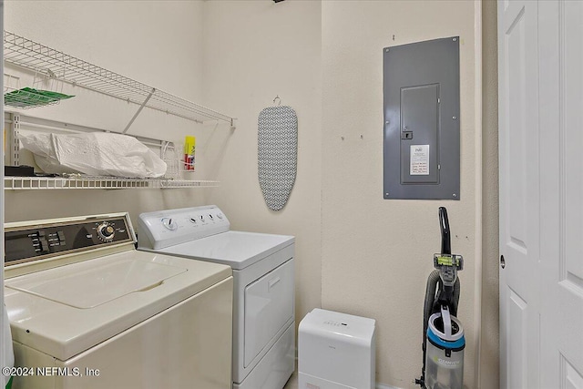 laundry area featuring electric panel and washing machine and clothes dryer