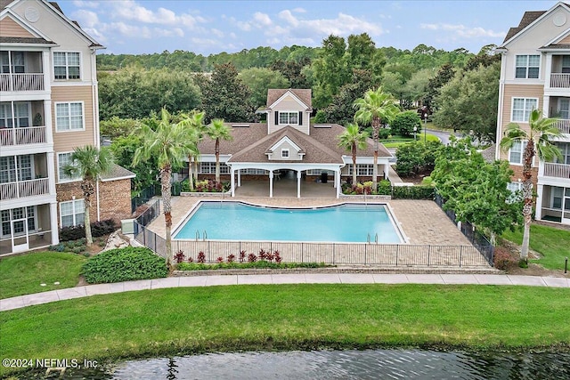 view of pool with a water view and a patio