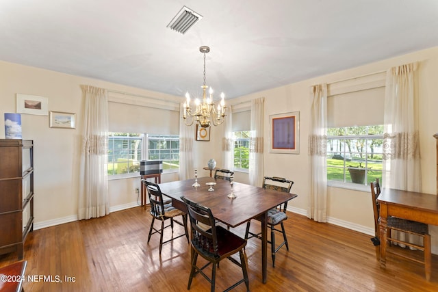 dining room featuring wood-type flooring and an inviting chandelier