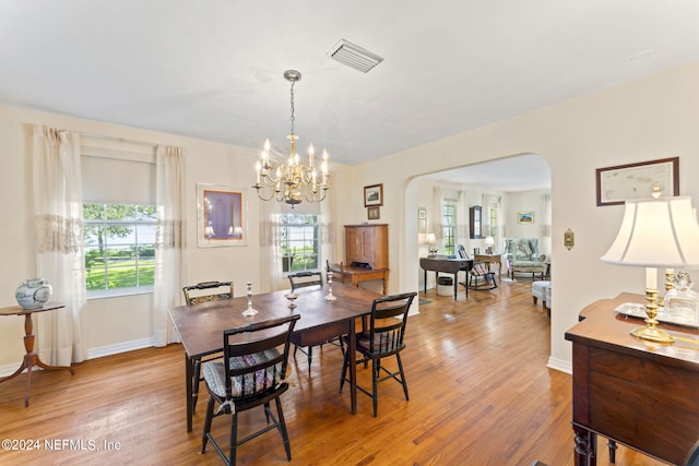 dining room with a notable chandelier and light wood-type flooring