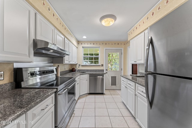 kitchen with light tile patterned floors, appliances with stainless steel finishes, sink, and white cabinetry