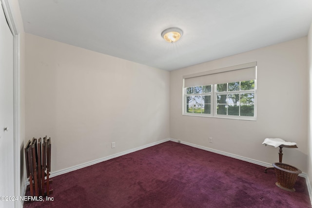 unfurnished room featuring dark carpet