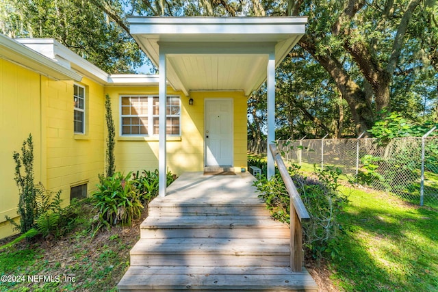 entrance to property with a lawn