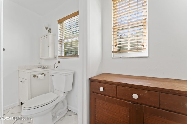 bathroom with vanity, tile patterned flooring, toilet, and a healthy amount of sunlight