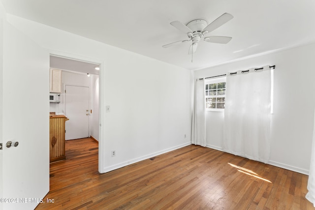 empty room with hardwood / wood-style flooring and ceiling fan