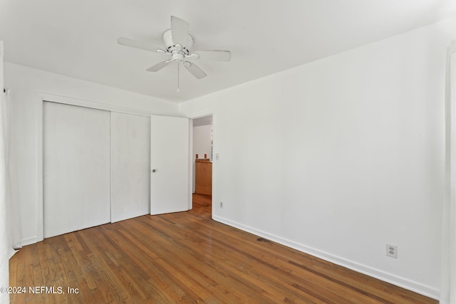 unfurnished bedroom featuring a closet, hardwood / wood-style flooring, and ceiling fan