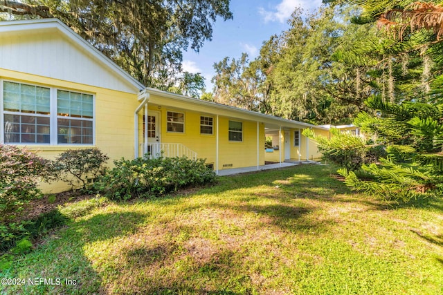 rear view of property featuring a lawn