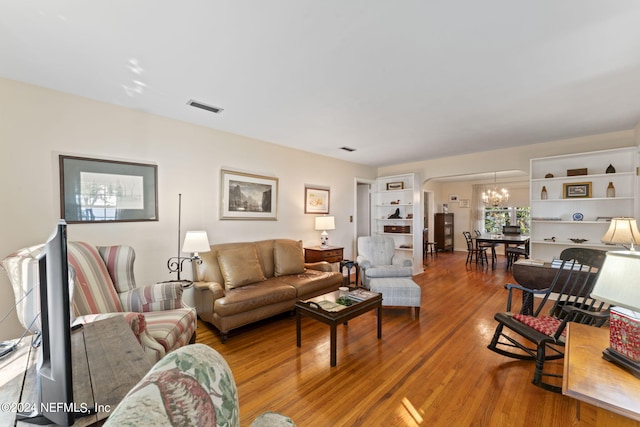 living room with hardwood / wood-style floors and an inviting chandelier