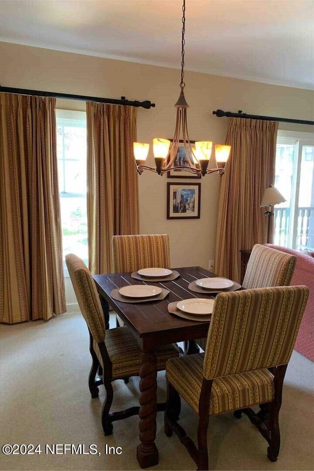 dining room with a notable chandelier, plenty of natural light, and carpet flooring