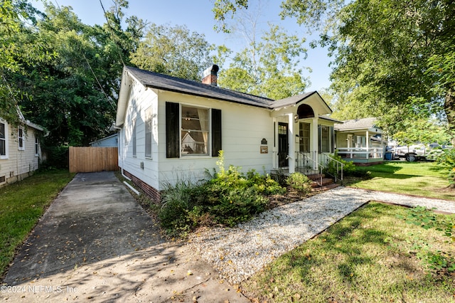 bungalow-style home featuring a front lawn and a porch