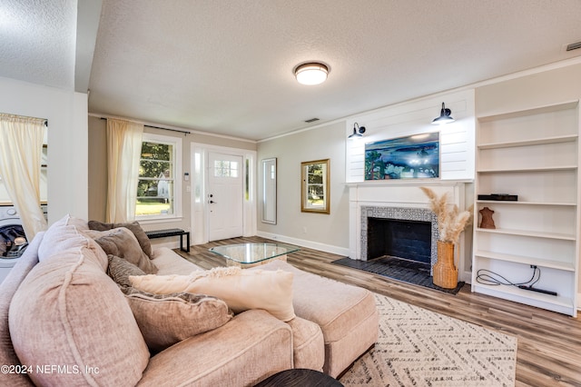 living room featuring a textured ceiling, a fireplace, and hardwood / wood-style floors