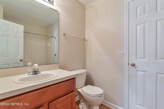 bathroom with a shower, vanity, toilet, and tile patterned flooring