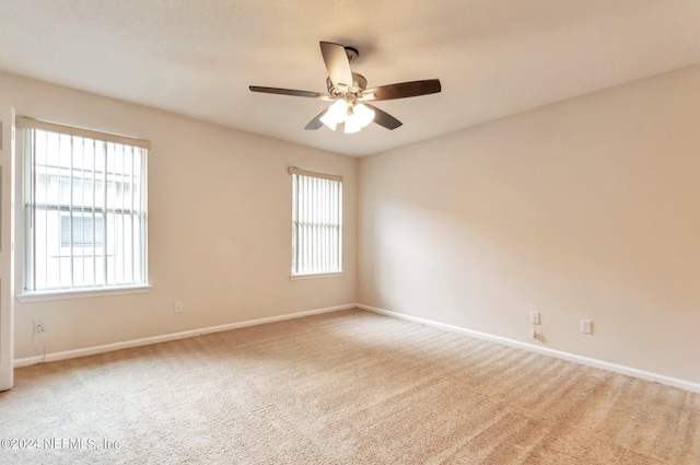 unfurnished room featuring carpet flooring, ceiling fan, and a wealth of natural light