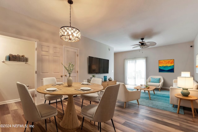 dining space featuring ceiling fan with notable chandelier and hardwood / wood-style flooring