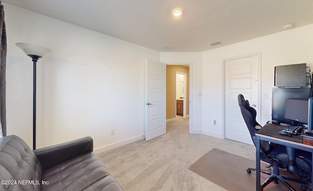 home office featuring light colored carpet and a textured ceiling