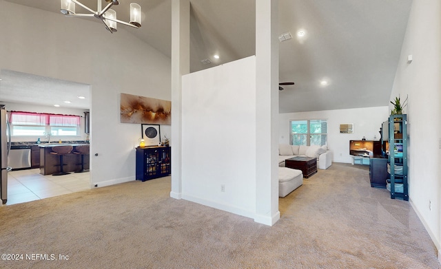 hall with high vaulted ceiling, light colored carpet, and a wealth of natural light