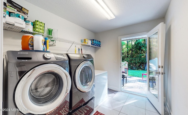 laundry room with a textured ceiling, separate washer and dryer, and light tile patterned floors