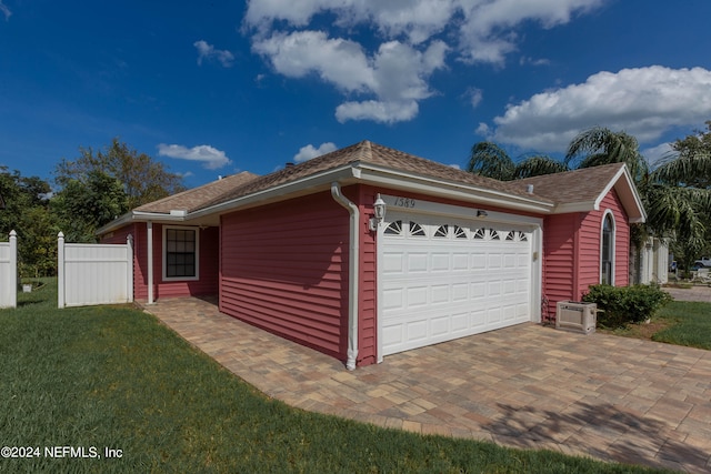 view of front of house with a front lawn, ac unit, an attached garage, and fence