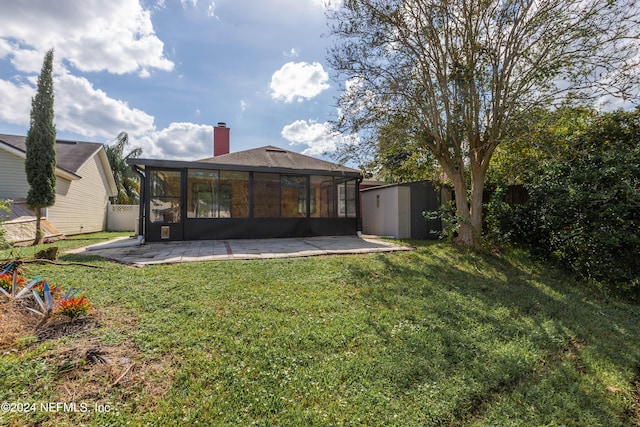 back of property with a storage shed, a sunroom, a patio, and a lawn