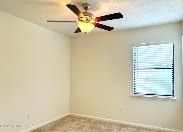 unfurnished room with a ceiling fan, light carpet, a textured ceiling, and baseboards