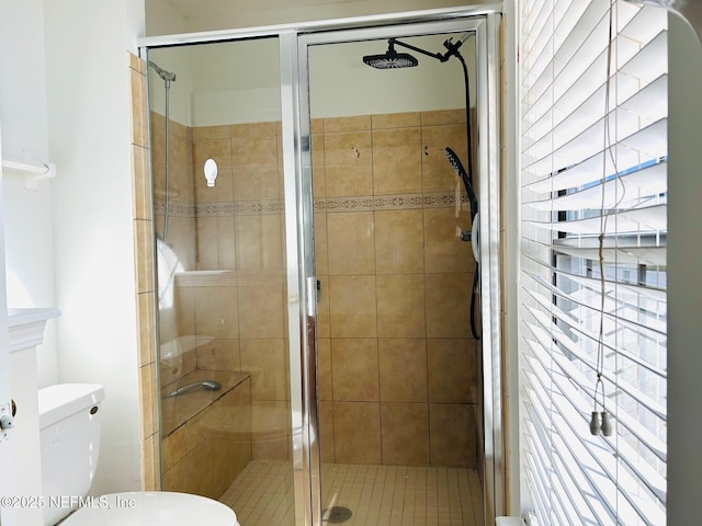 bathroom with a shower with shower door and toilet