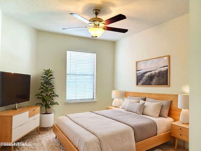 bedroom with a ceiling fan and a textured ceiling