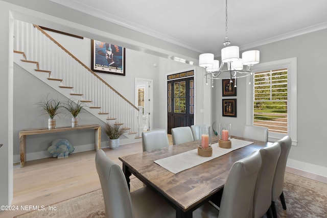 dining space featuring crown molding, light hardwood / wood-style floors, and a chandelier