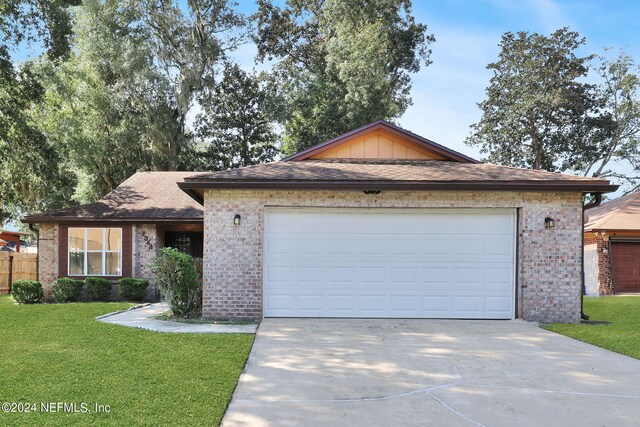 ranch-style home featuring a front lawn and a garage