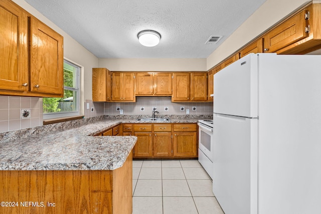 kitchen with decorative backsplash, white appliances, light tile patterned floors, a textured ceiling, and sink