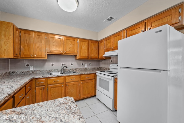 kitchen featuring light tile patterned floors, sink, white appliances, a textured ceiling, and backsplash