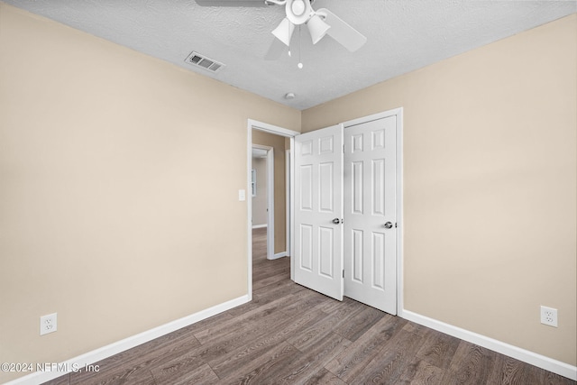 unfurnished bedroom featuring ceiling fan, hardwood / wood-style flooring, a closet, and a textured ceiling